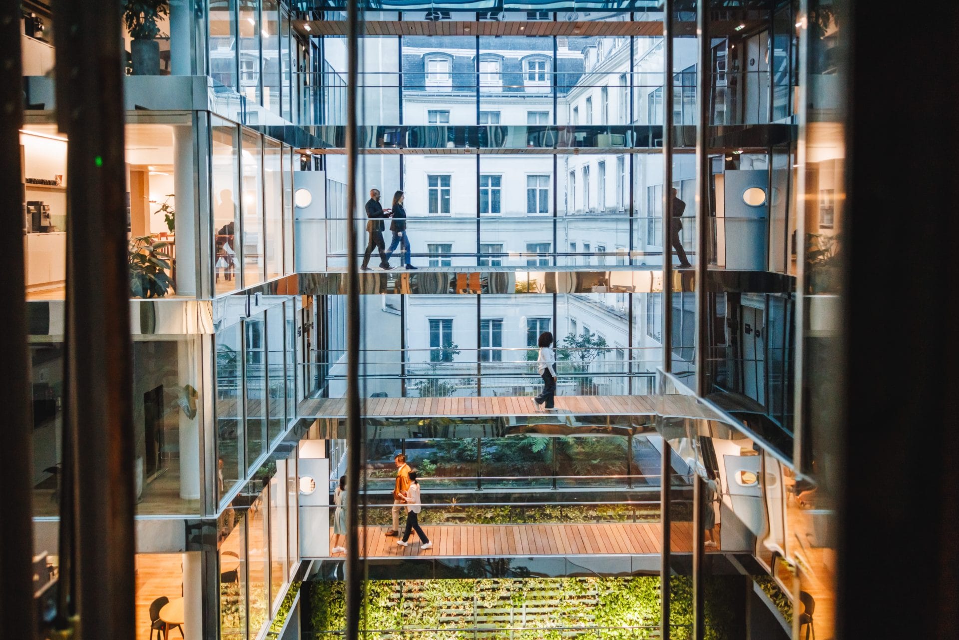 Bright multi-story office atrium with glass walls and plants
