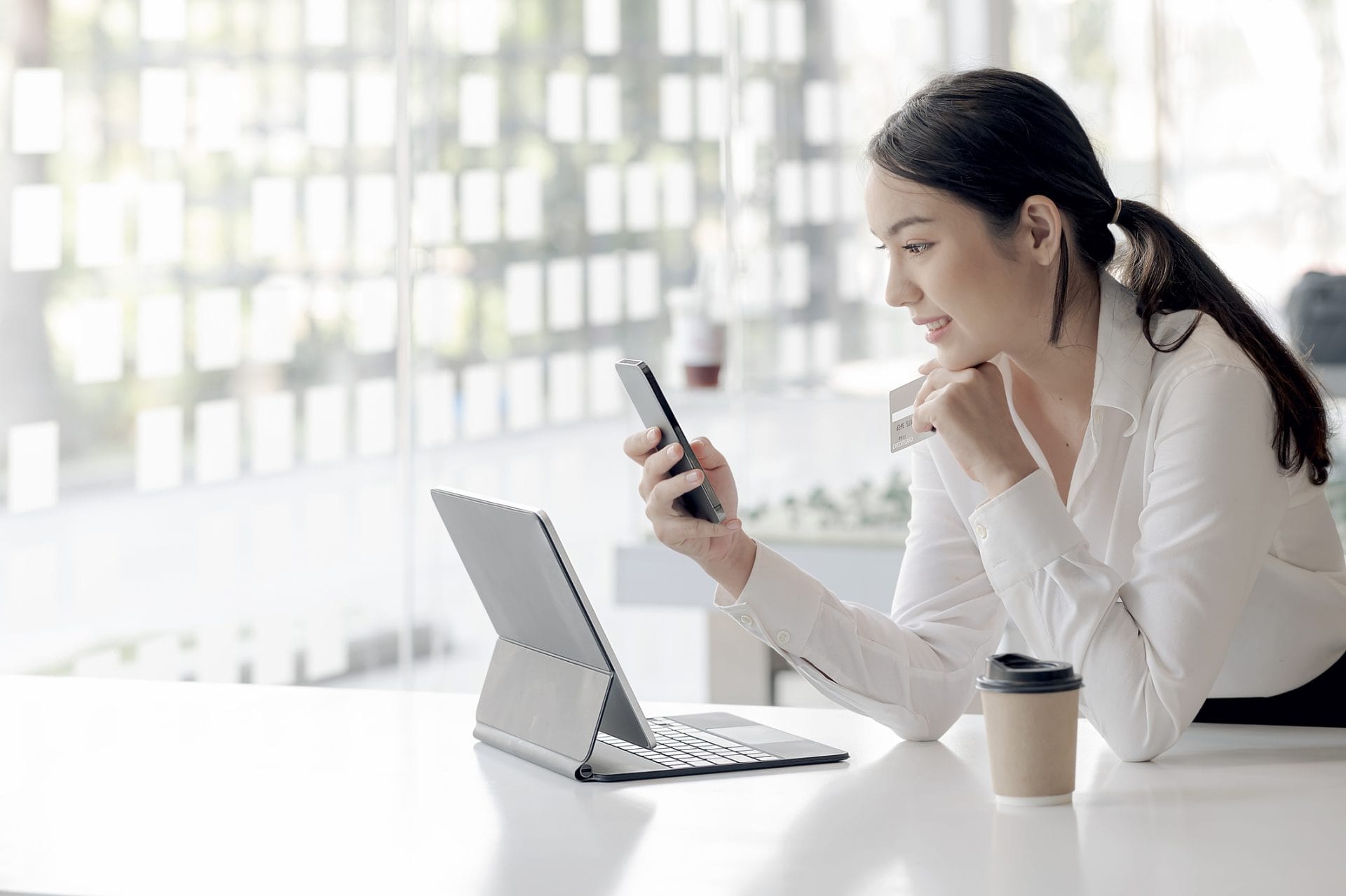 Woman smiling while using a laptop at a minimalist desk