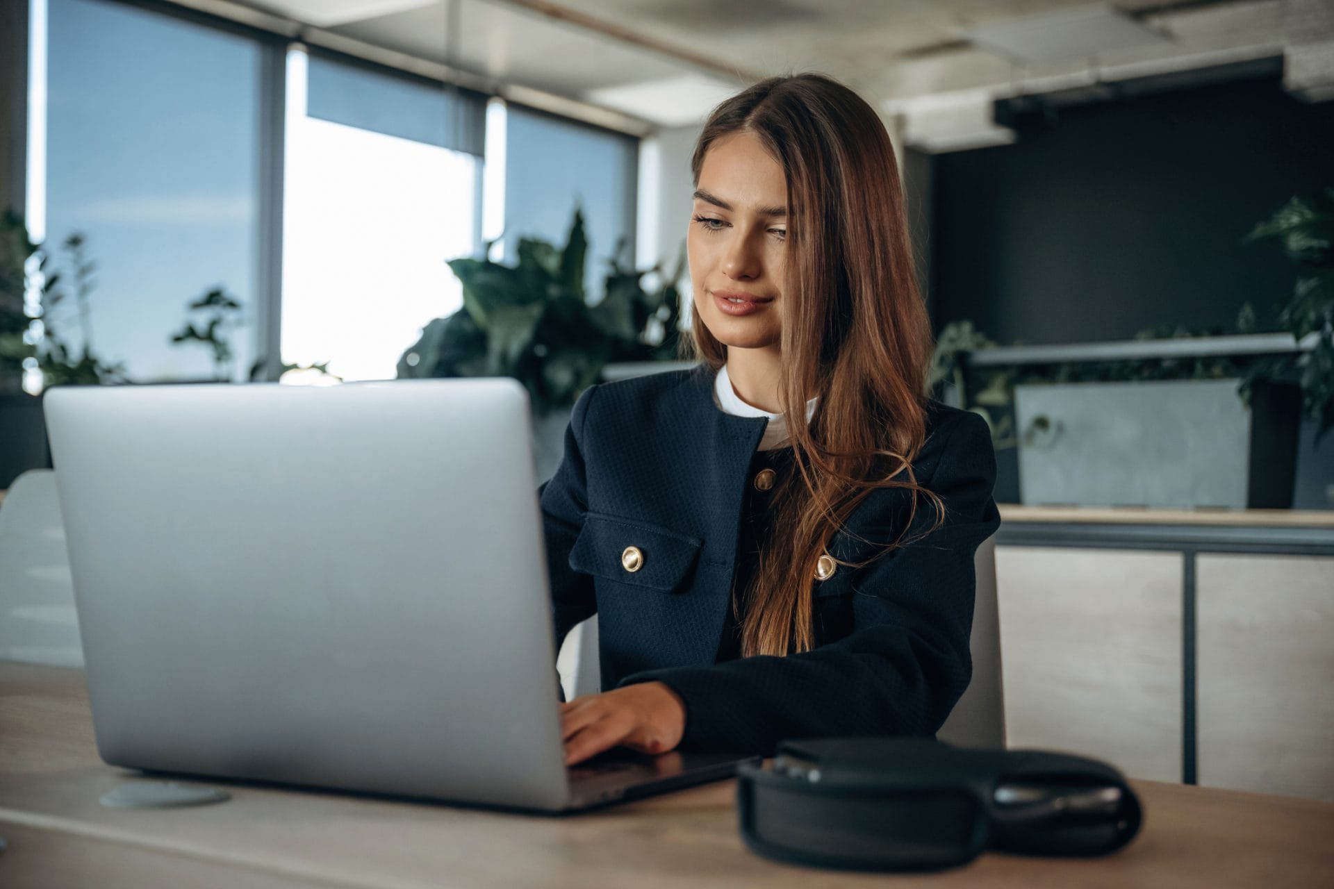 Woman working on a laptop at a desk in a contemporary office